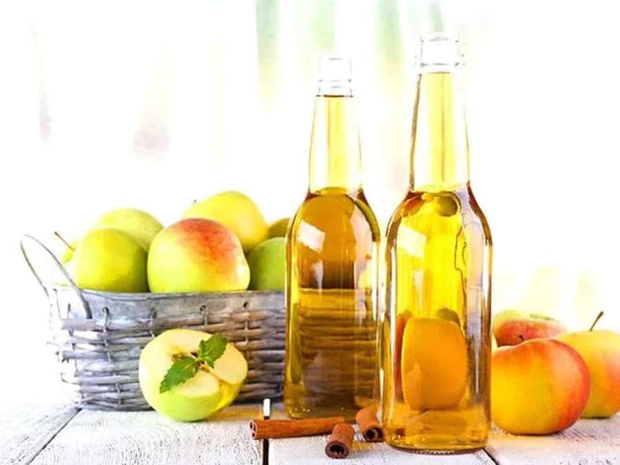 Duas garrafas de cidra de maçã com maçãs e paus de canela sobre uma mesa de madeira. — Vinagre de maçã Papéis de Parede