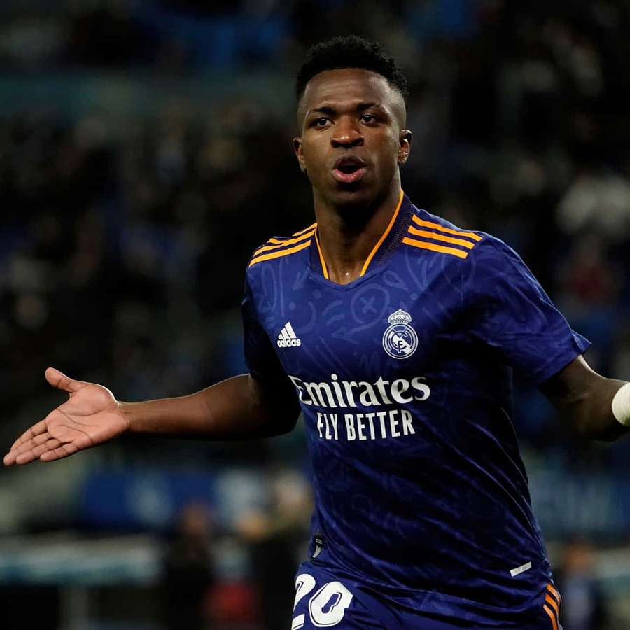 Football player in blue Real Madrid jersey gesturing during night match. — Vinicius Jr Wallpaper