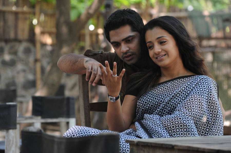 A smiling couple sharing an intimate outdoor moment under trees. — Vinnaithandi Varuvaya HD Wallpaper