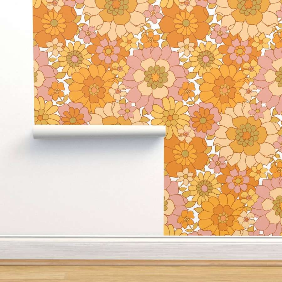 Retro floral wallpaper in orange pink and cream tones being unrolled on a white wall. — Vintage 70s Background