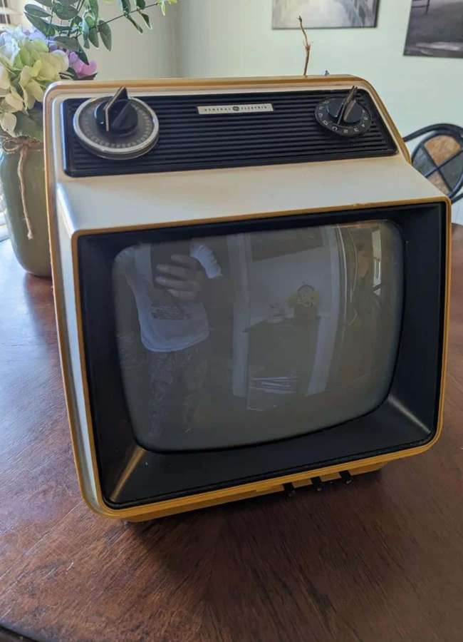A retro TV on a wooden table showing a reflection of the photographer. — Vintage Watch Wallpaper