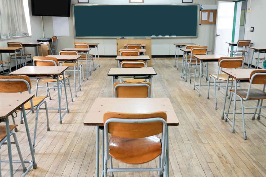Empty classroom with wooden desks chairs and chalkboard under natural light — Virtual Classroom Background