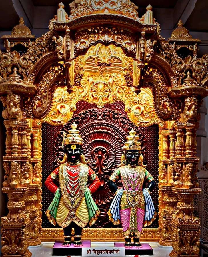 Two decorated deity statues in a golden temple shrine. — Vitthal Rukmini Background