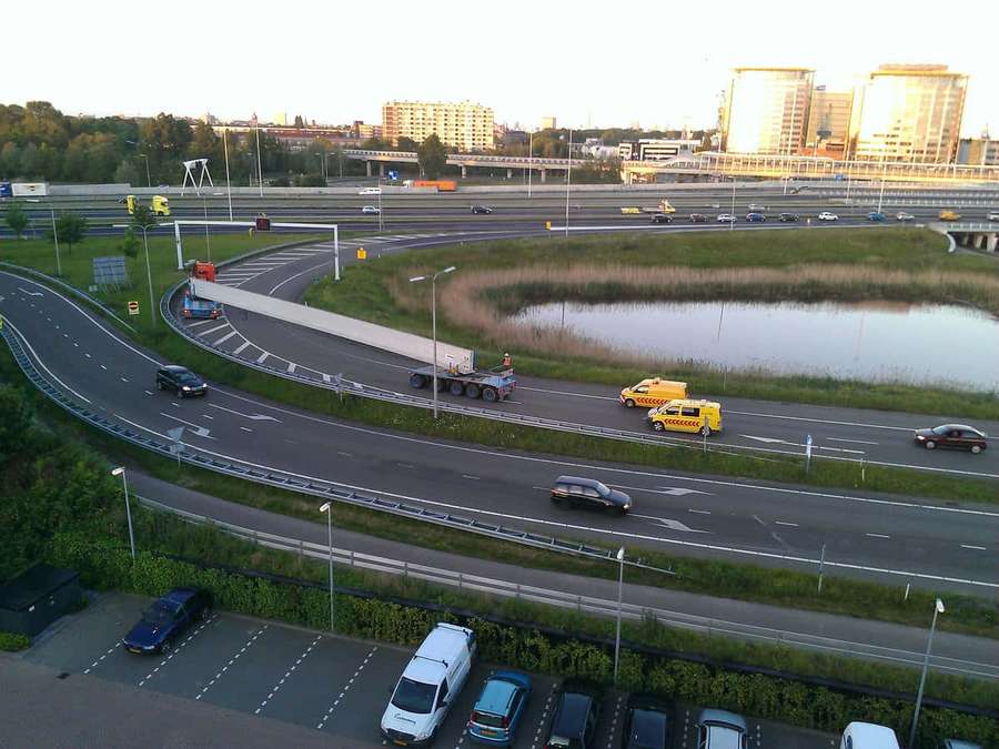 Persimpangan jalan raya dengan mobil dan taksi saat senja dekat kolam dan gedung kota. — Vlaardingen Wallpaper
