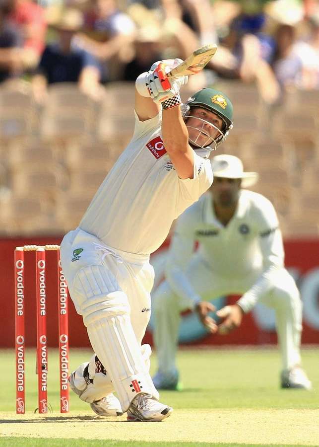 Cricketspiller svinger bat under dagkamp på græsbane. — Warner Wallpapers