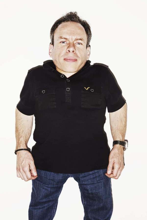 Man wearing black polo shirt and jeans in studio portrait — Warwick Davis Picture