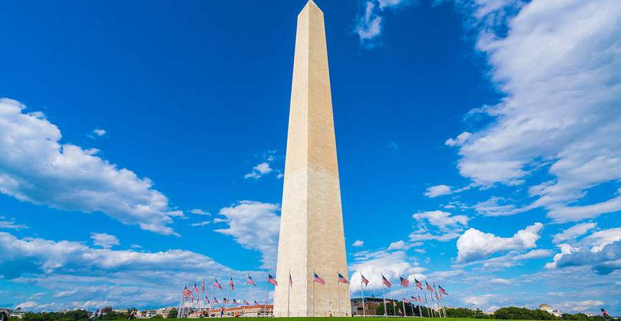 Washington Monument mit amerikanischen Flaggen unter einem hellblauen Himmel mit Wolken — Washington denkmal Wallpaper
