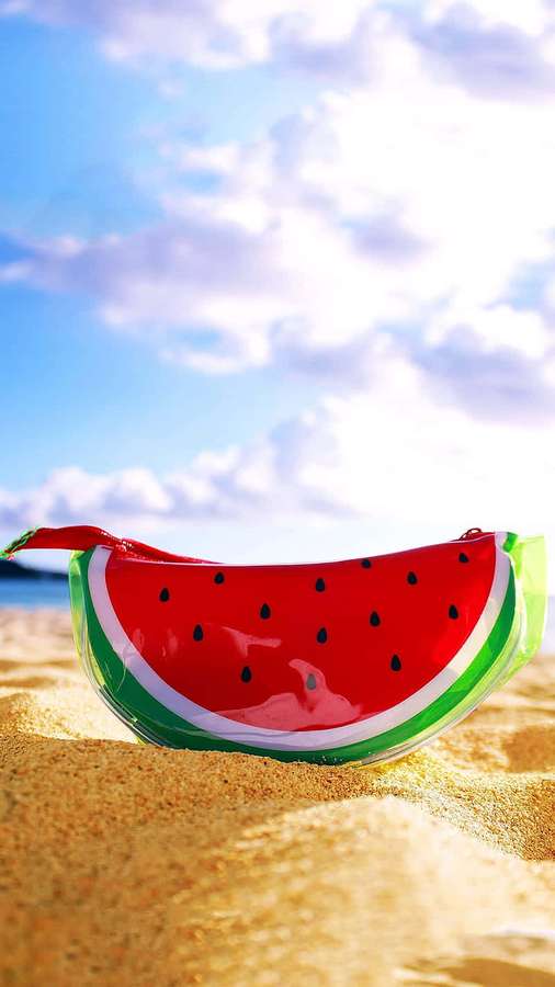 Wassermelonentasche auf sonnigem Strandsand unter blauem Himmel — Wassermelone iPhone Wallpaper