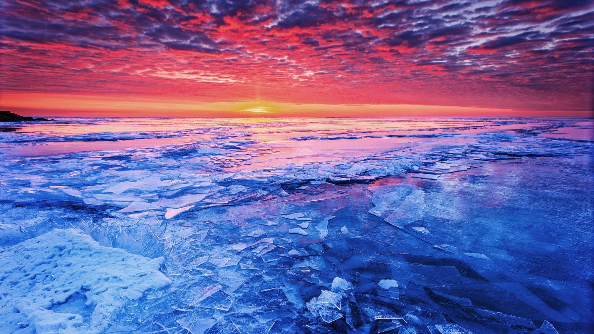 Mar congelado con hielo roto bajo un cielo vibrante al atardecer. — Weather Fondos de pantalla