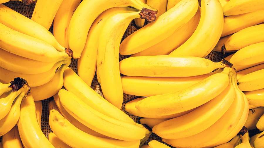 Reife gelbe Bananen in Büscheln auf einem Netzhintergrund. — Wegerich Bild Wallpaper