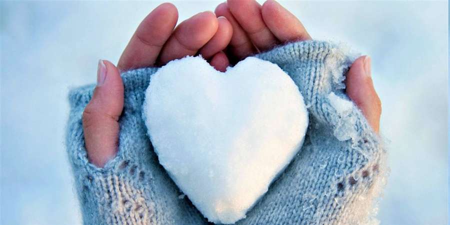 Hands in blue knit gloves gently holding a snow heart. — White Heart Wallpaper