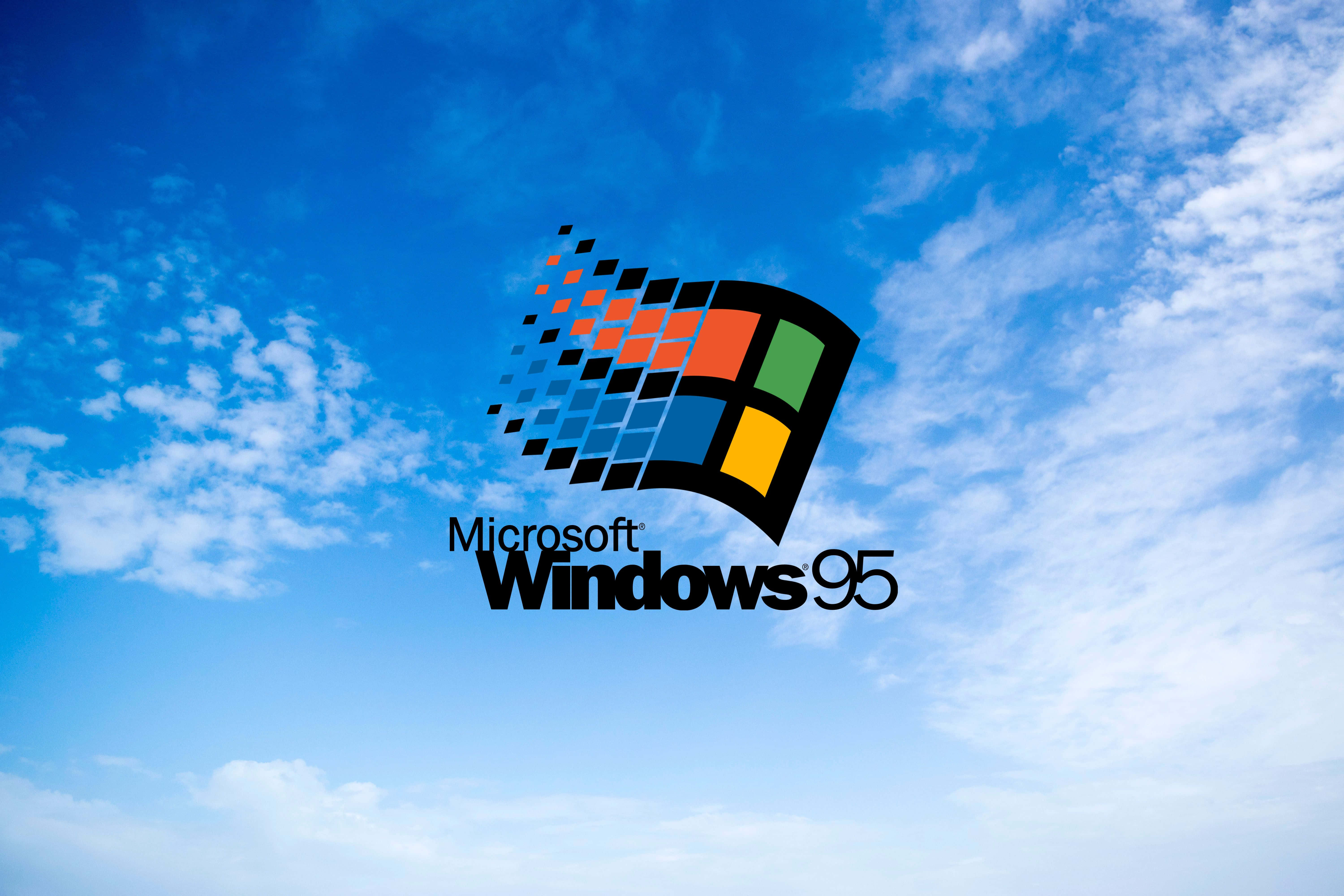 Windows 95 logo against a blue sky with white clouds — Windows 95 Wallpaper