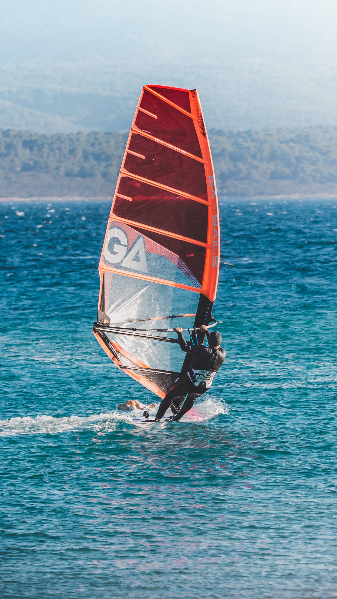 Windsurfare rider vågor med orange segel på blått hav nära stranden — Vindsurfing bakgrund Bakgrundsbilder