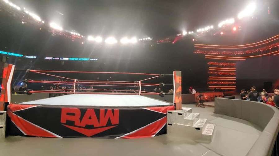 WWE RAW wrestling ring under bright arena lights with cheering crowd. — Wrestling Ring Background