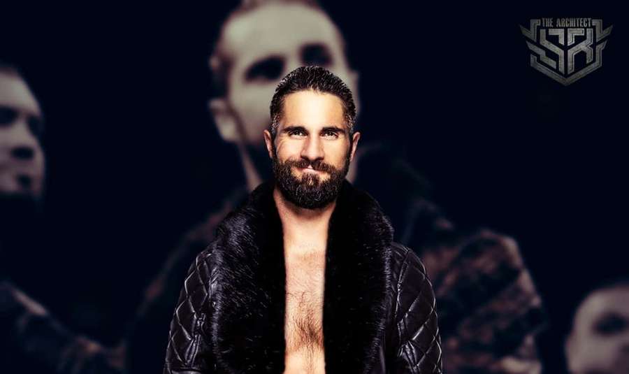 A bearded man in a black quilted jacket with fur collar stares confidently against a dark background with blurred faces and a logo. — WWE Desktop Background
