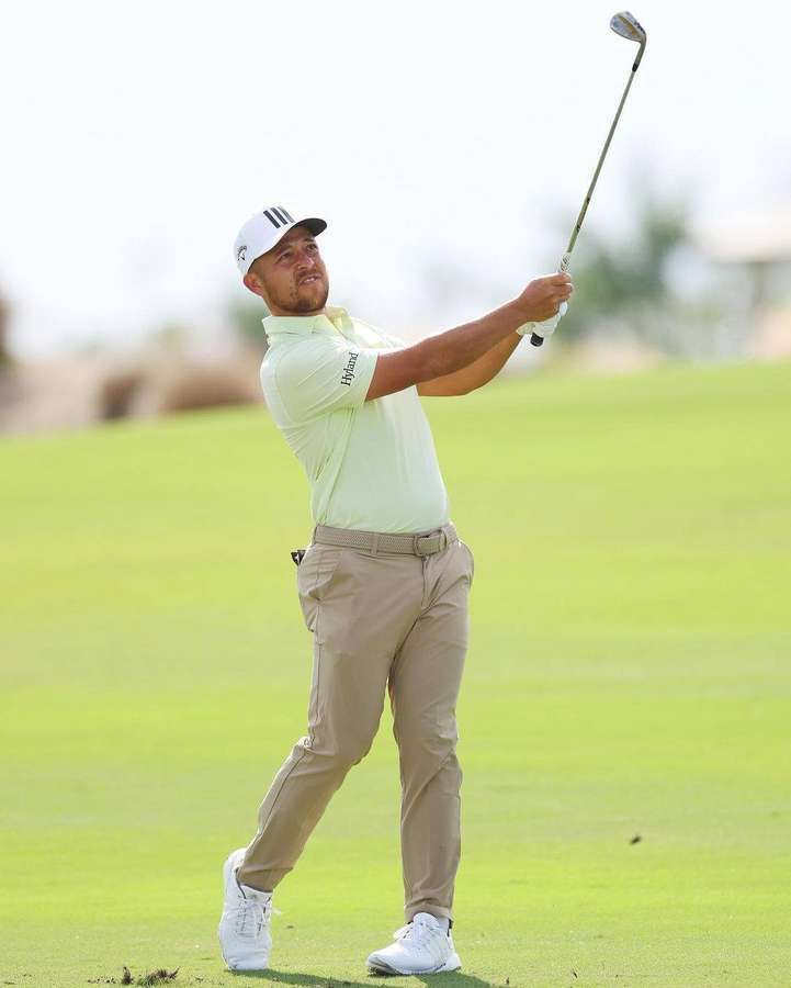 Male golfer mid-swing on a sunny golf course fairway. — Xander Schauffele Wallpaper