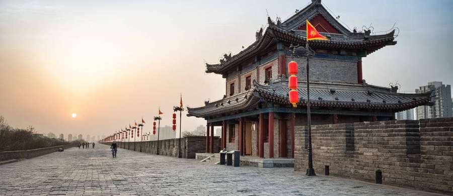 Sunset over ancient Chinese city wall with red lanterns and a watchtower. — Xian Wallpaper