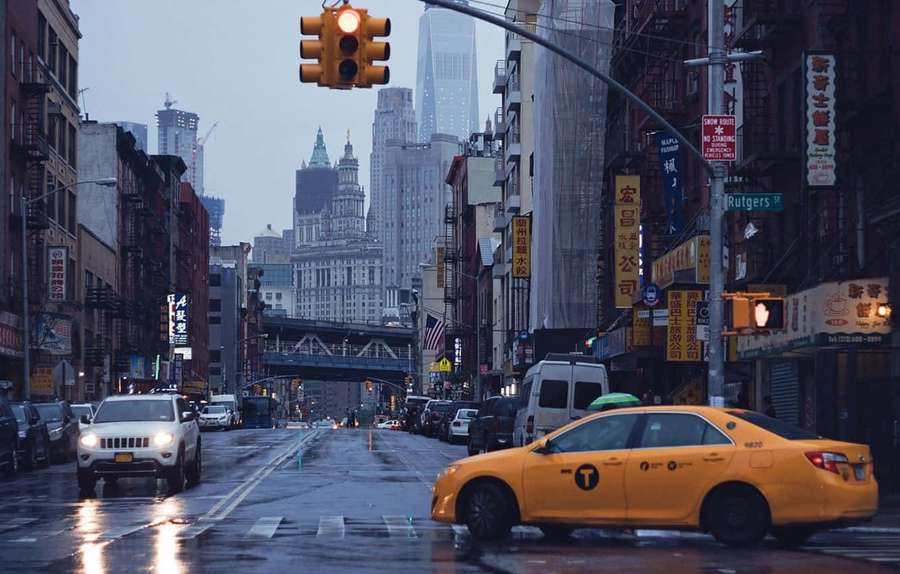 Yellow taxi on wet city street at dusk with glowing traffic lights and tall buildings. — Yellow Cab Wallpaper