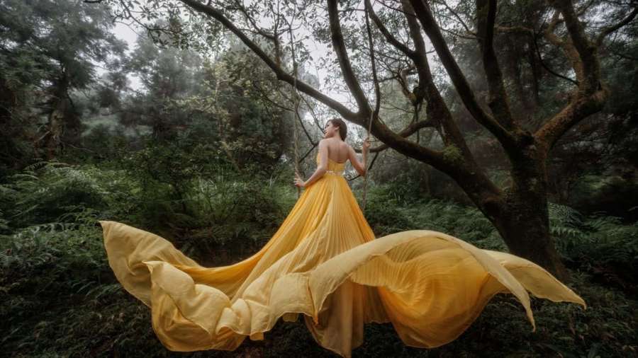 Woman in yellow dress swinging in misty forest — Yellow Dress Wallpaper