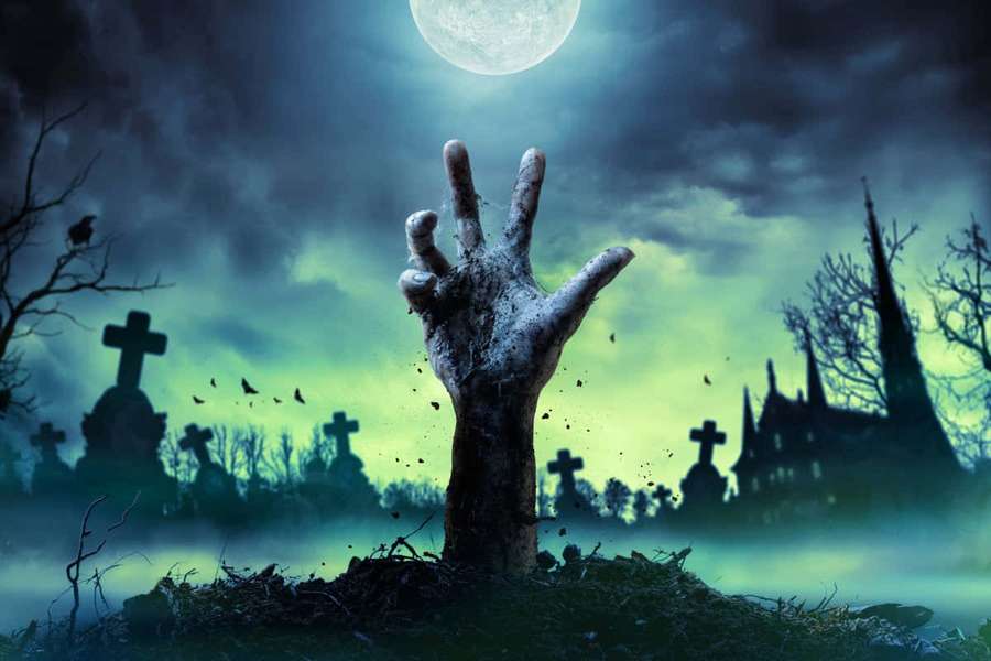 Zombie hand emerging from grave under full moon in eerie cemetery. — Zombie Picture