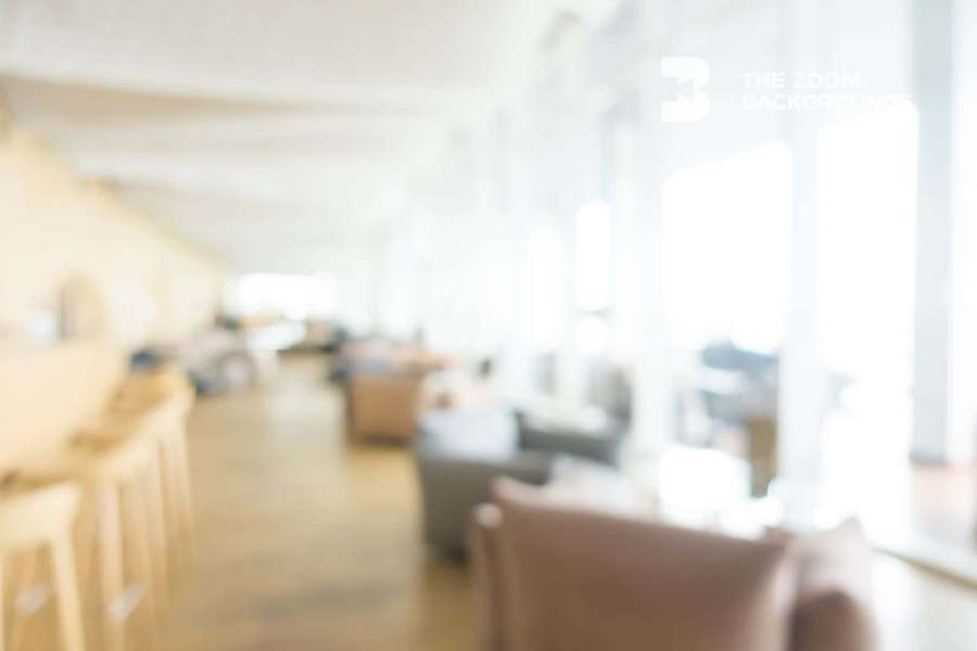Blurred view of a modern indoor lounge with wooden floors and soft lighting. — Zoom Blur Background