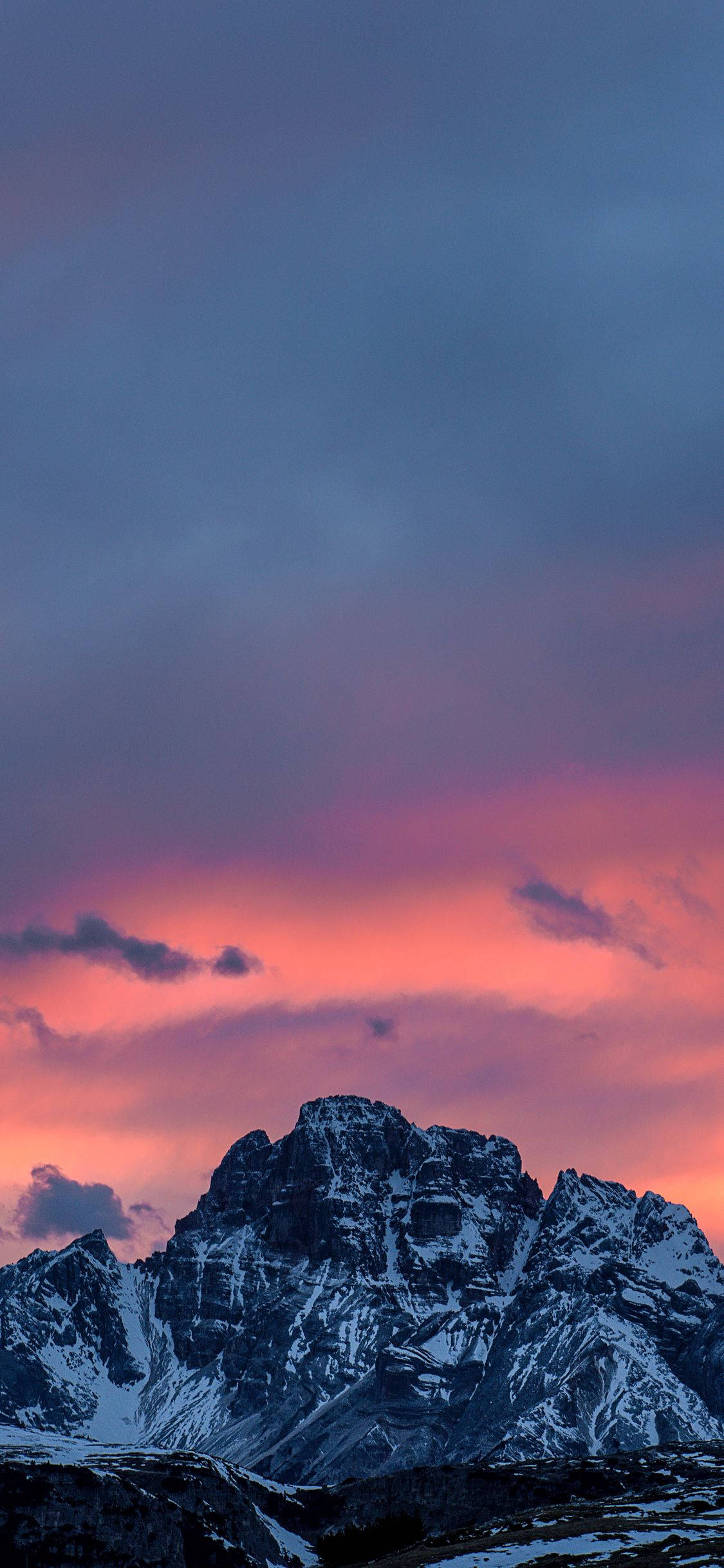 A Mountain Range With A Pink Sky Background