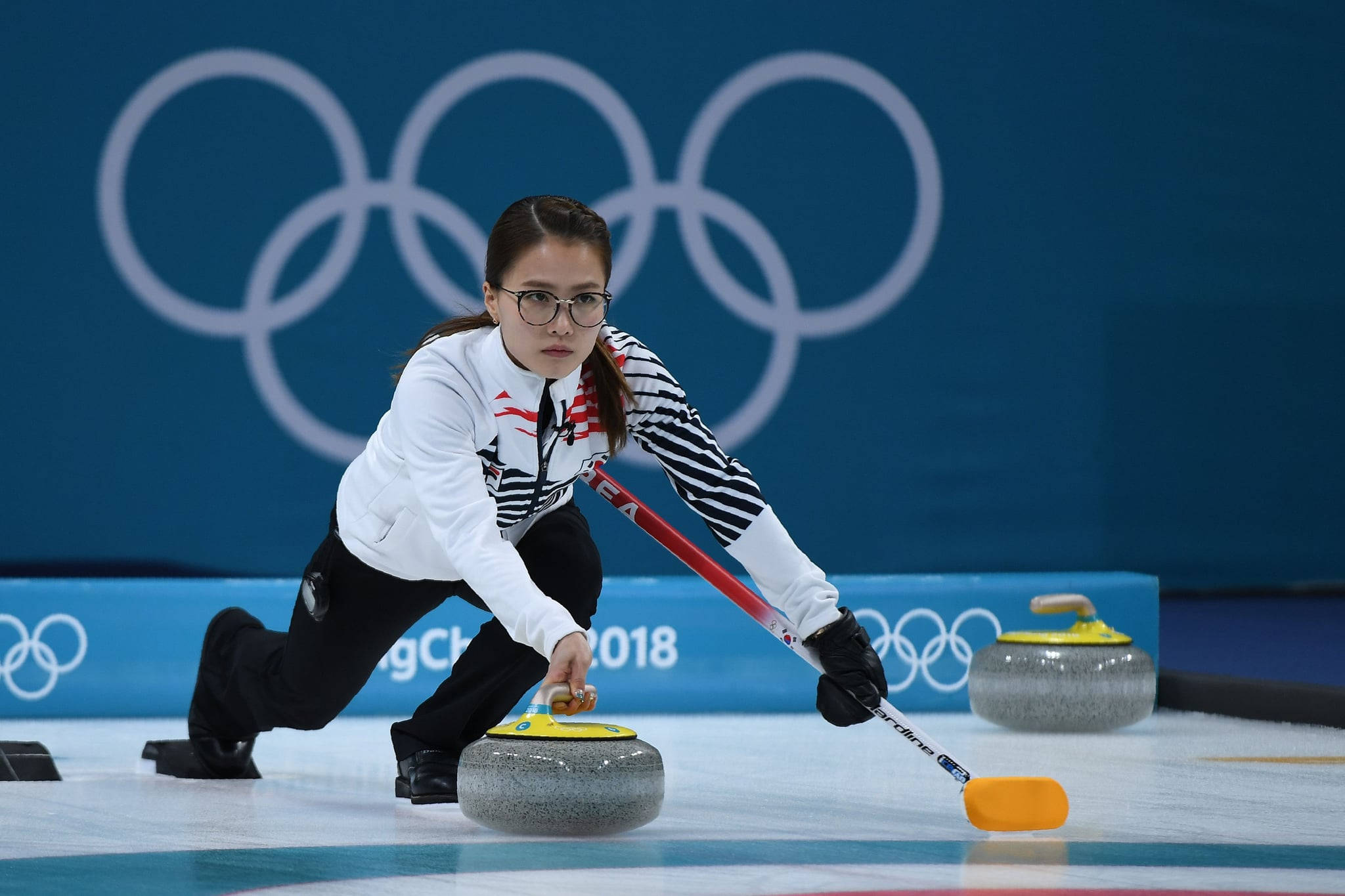 Download Female Curling Athlete At The Winter Olympics Wallpaper