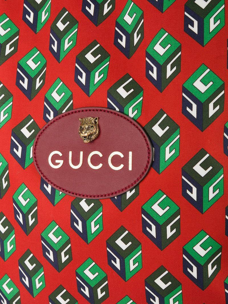 Gucci Logo On A Red Bag With Green And Blue Squares Background