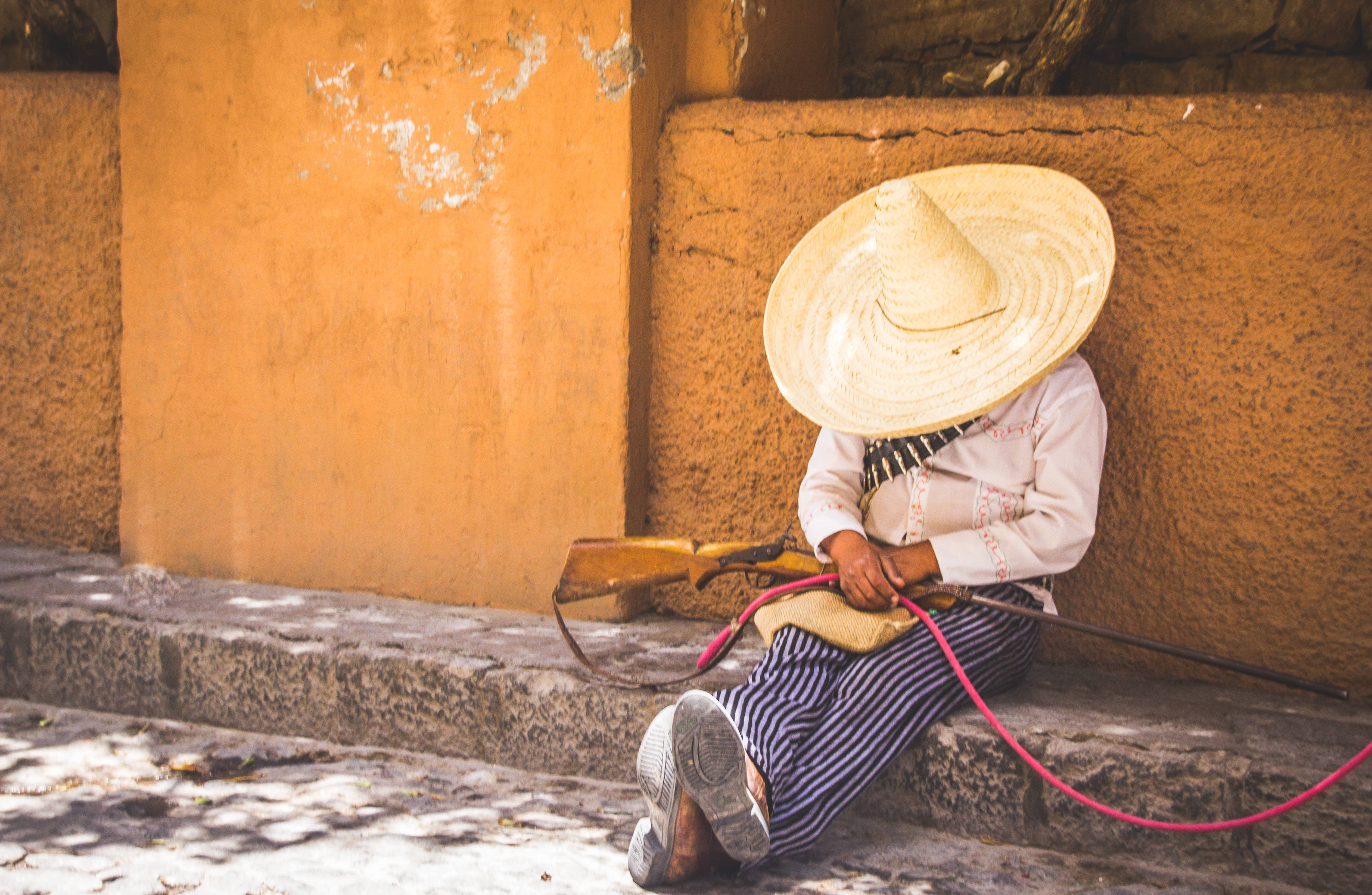 Download Mexican Man White Hat With Rifle Wallpaper | Wallpapers.com