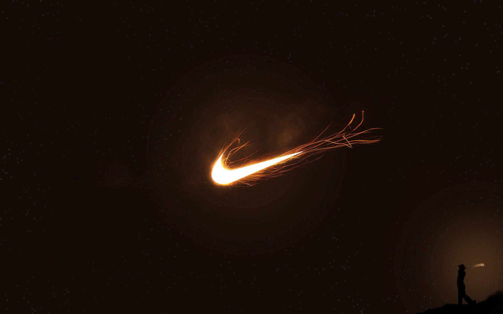 Nike Logo In The Dark With A Person Standing In Front Of It Background