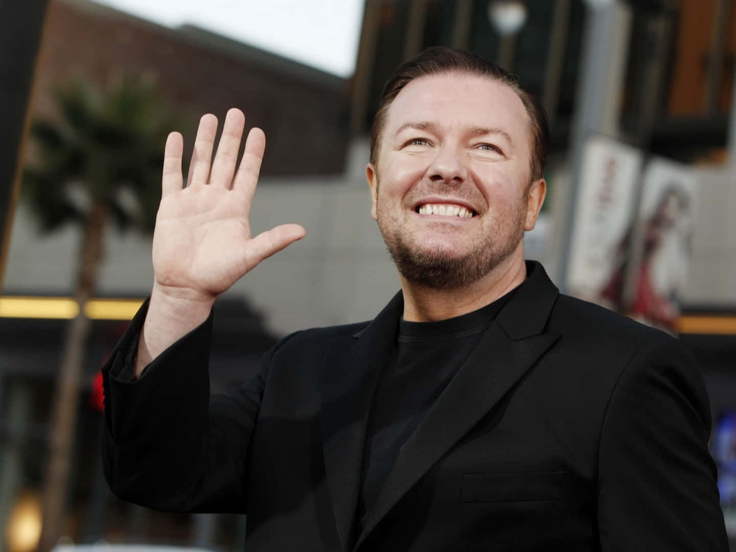 Download Ricky Gervais Smiling For A Photoshoot Wallpaper | Wallpapers.com