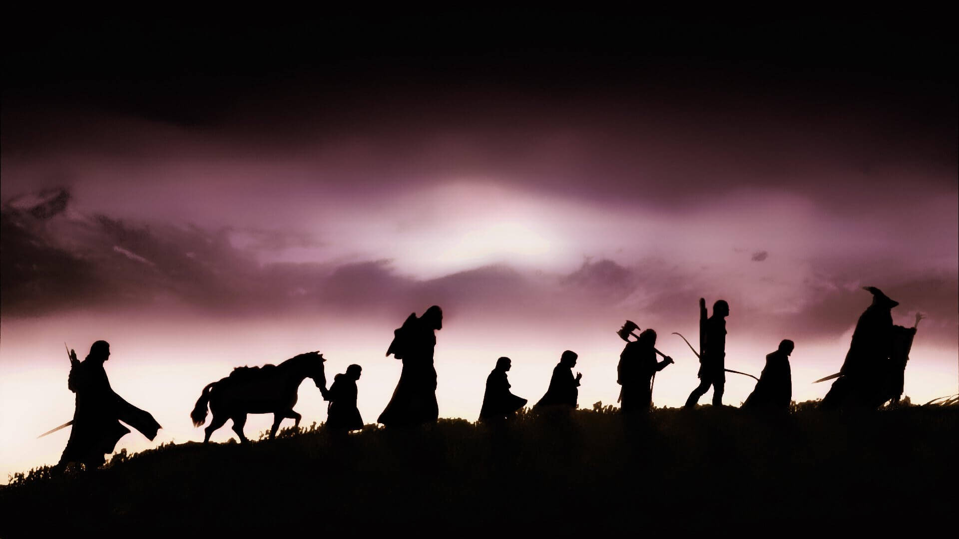 Silhouettes Of People On A Hill With A Dark Sky Background