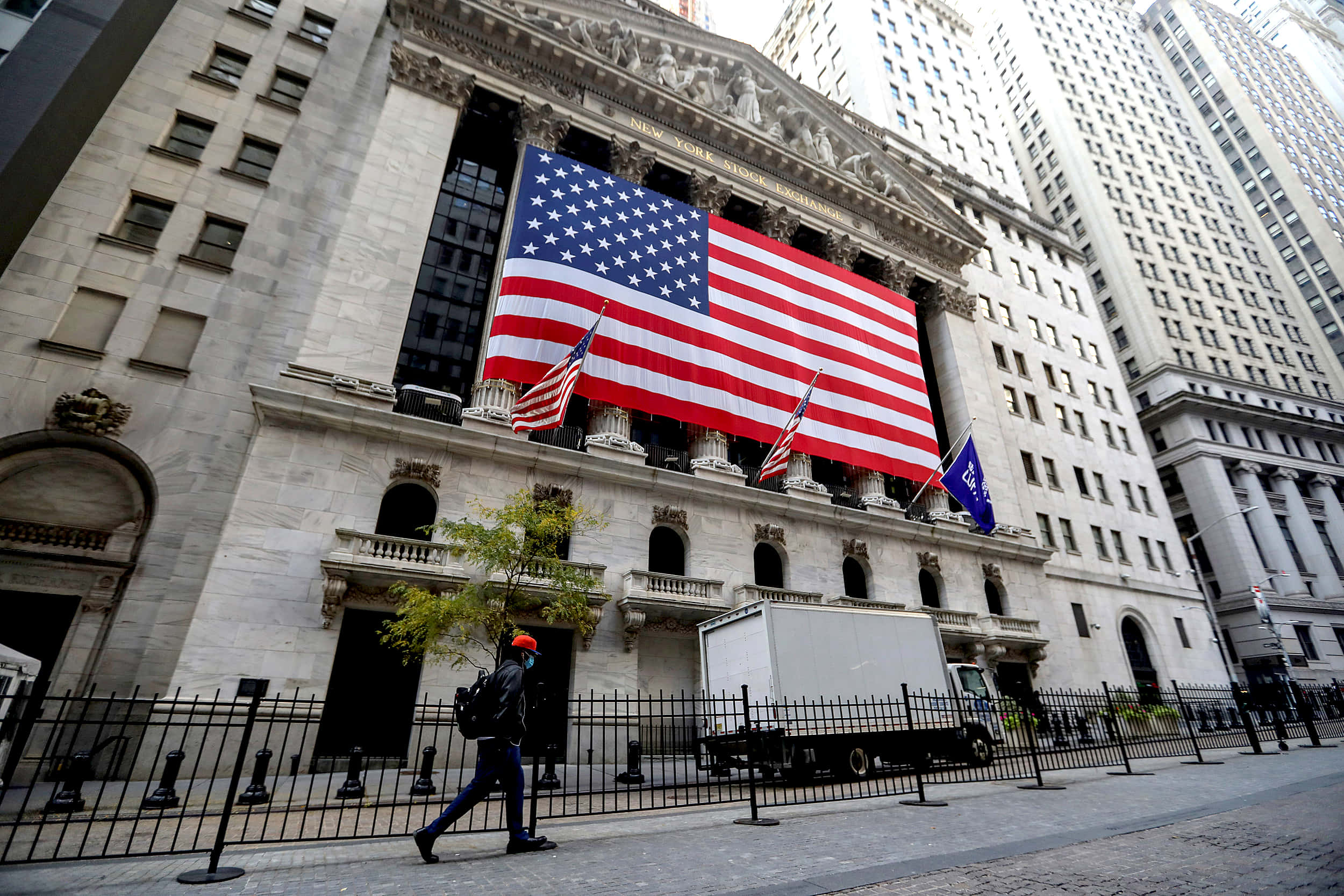 Download A Man Walks Past A Building With An American Flag Wallpaper ...