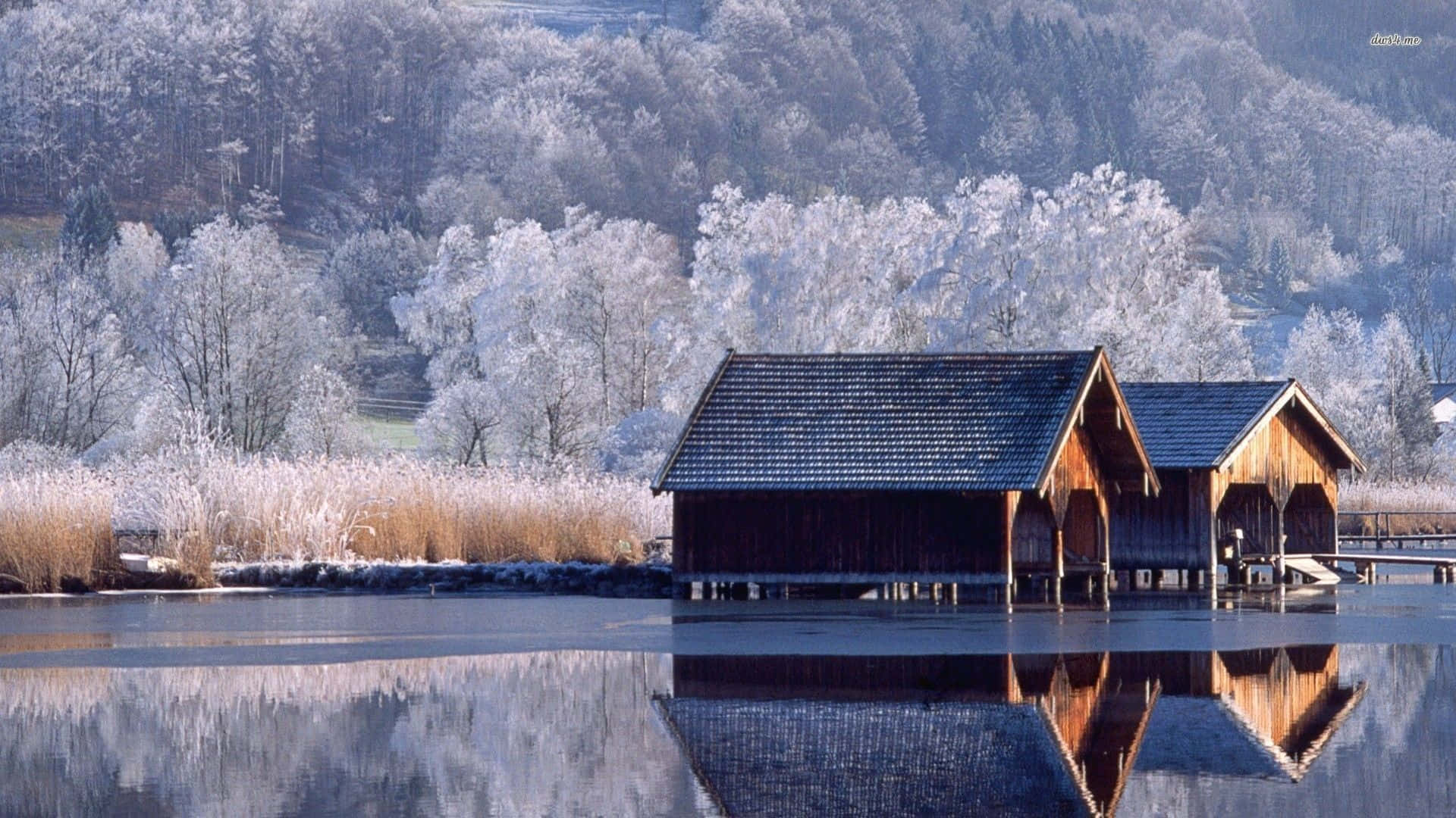 Two Wooden Cabins On A Frozen Lake