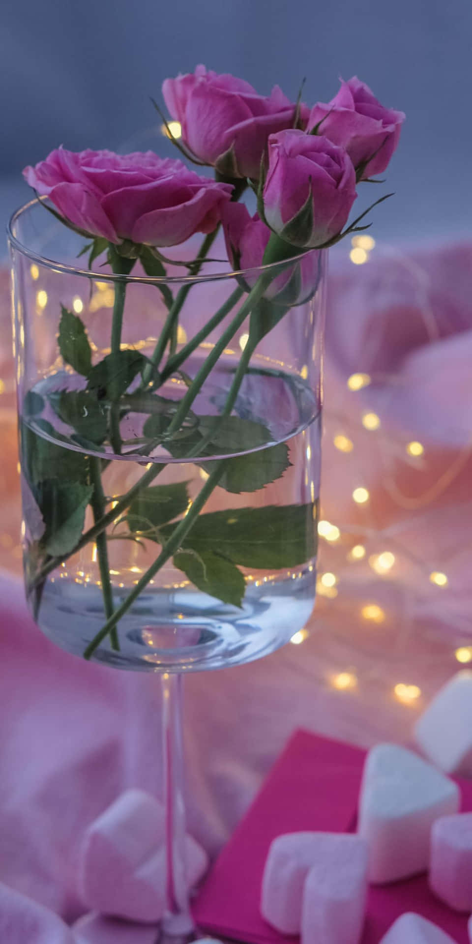 Pink Roses In A Glass With Water And Candy Wallpaper