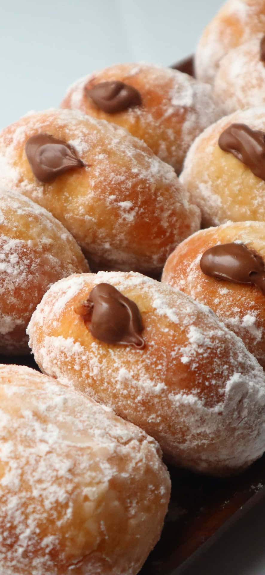 A Plate Of Donuts With Chocolate And Powdered Sugar Wallpaper