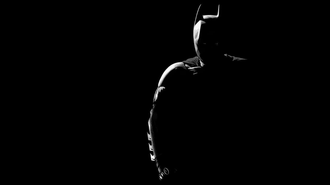 batman in the dark silhouetted against a black background