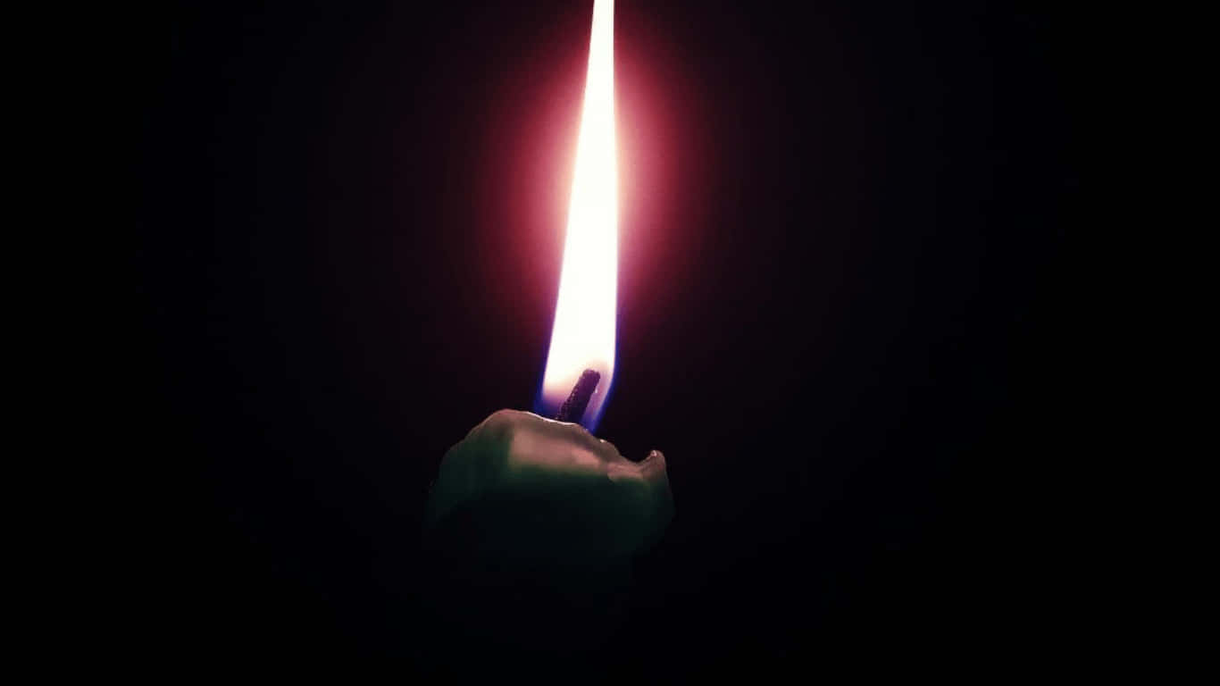 a lit candle is shown against a black background