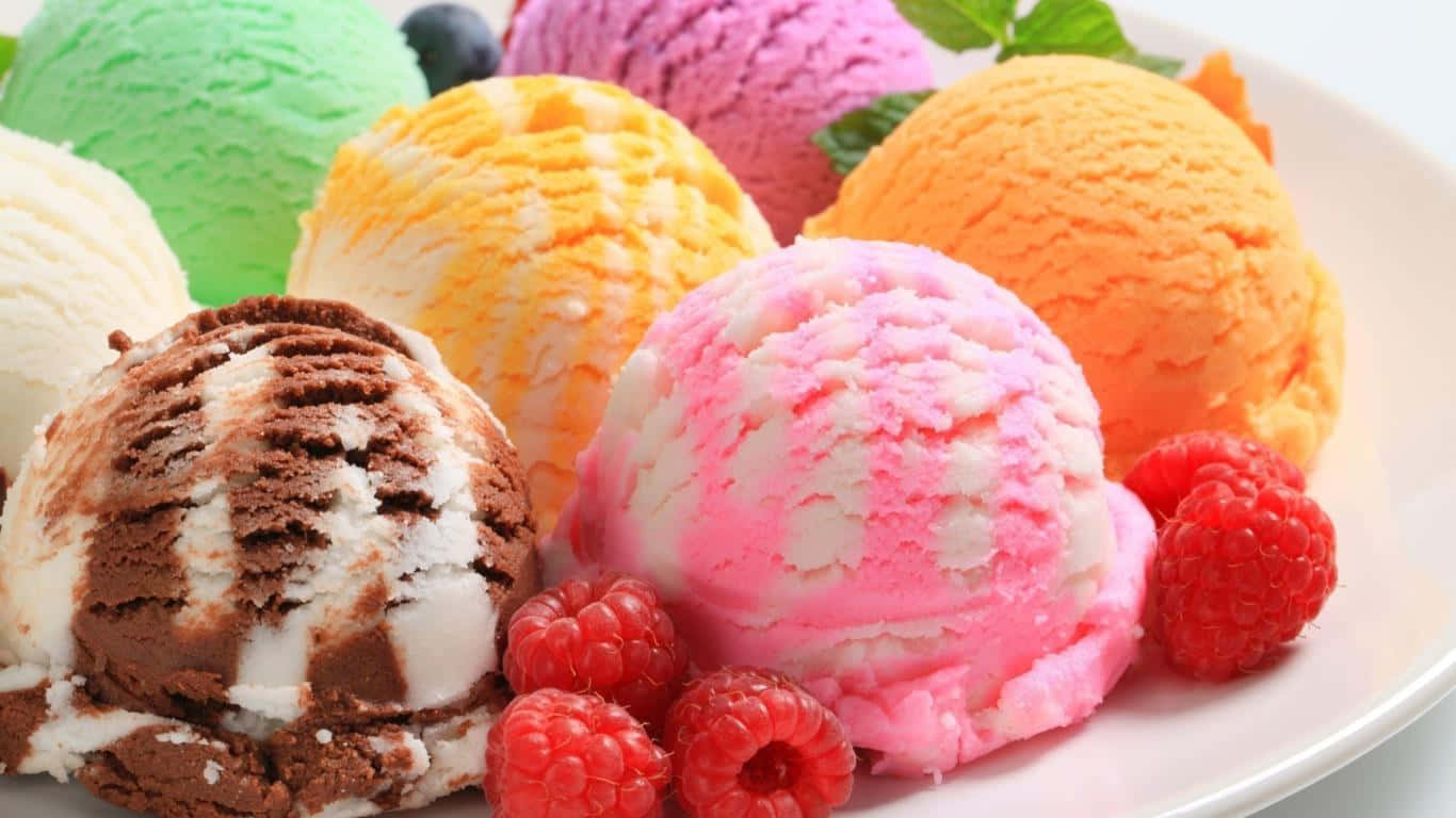 A Plate With Different Colored Ice Creams And Berries