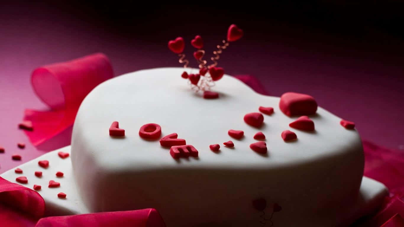 A White Cake With Red Hearts And Red Ribbons