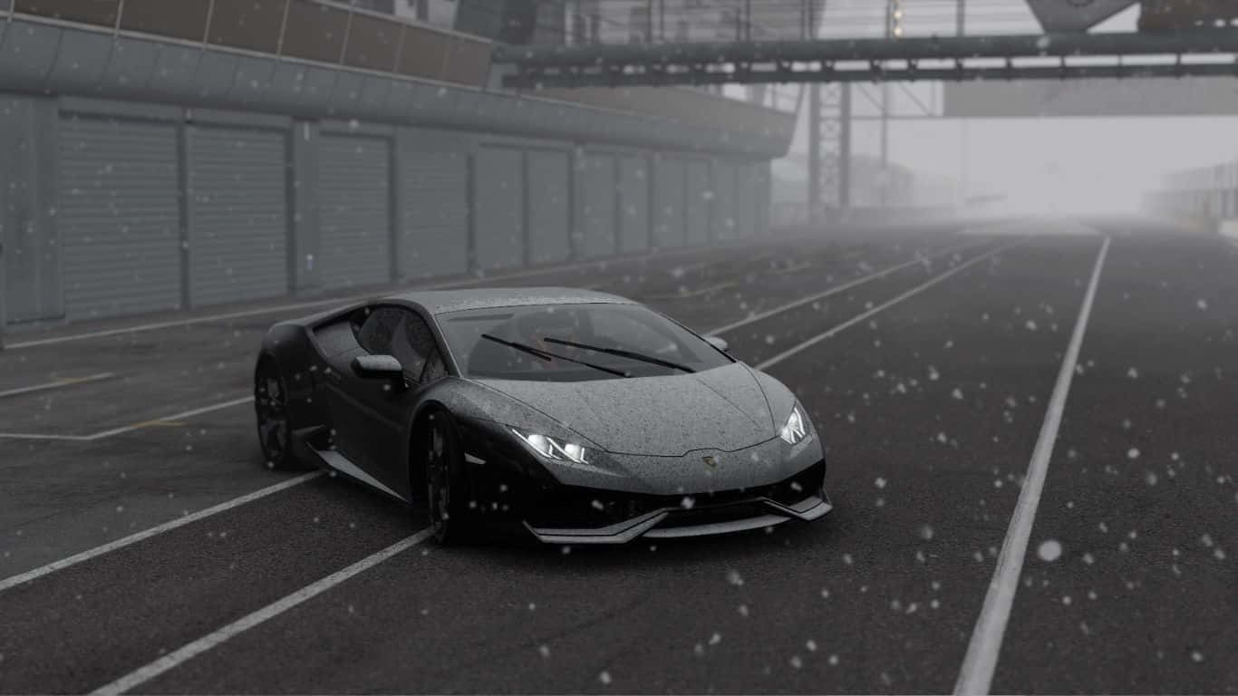 A Black Sports Car Driving Down A Snowy Road