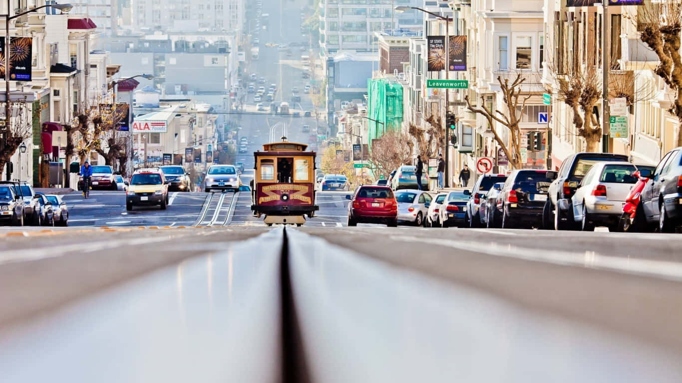 A Cable Car Is Driving Down A City Street