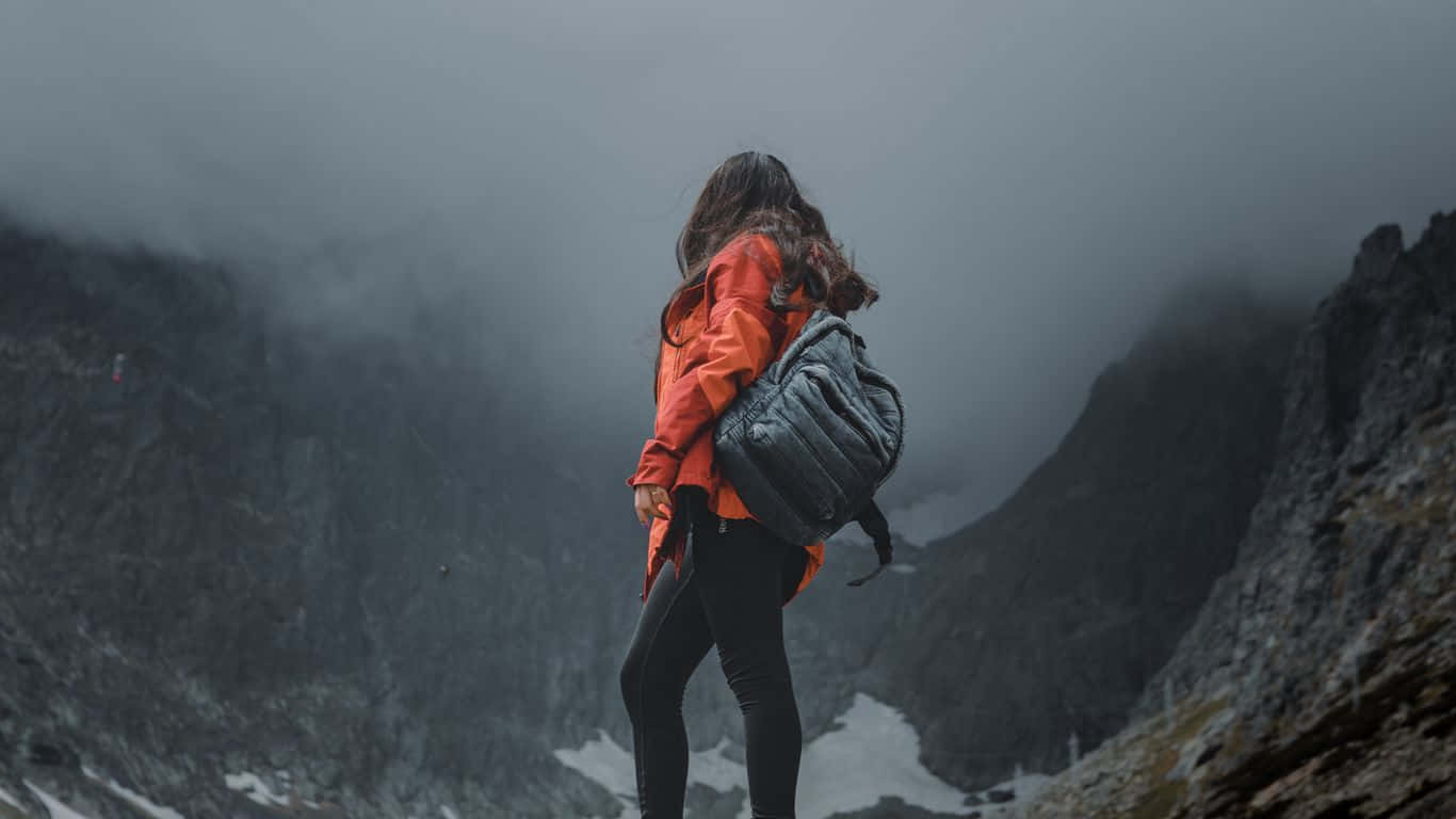 1366x768 Woman On Icy Mountain Travel Background