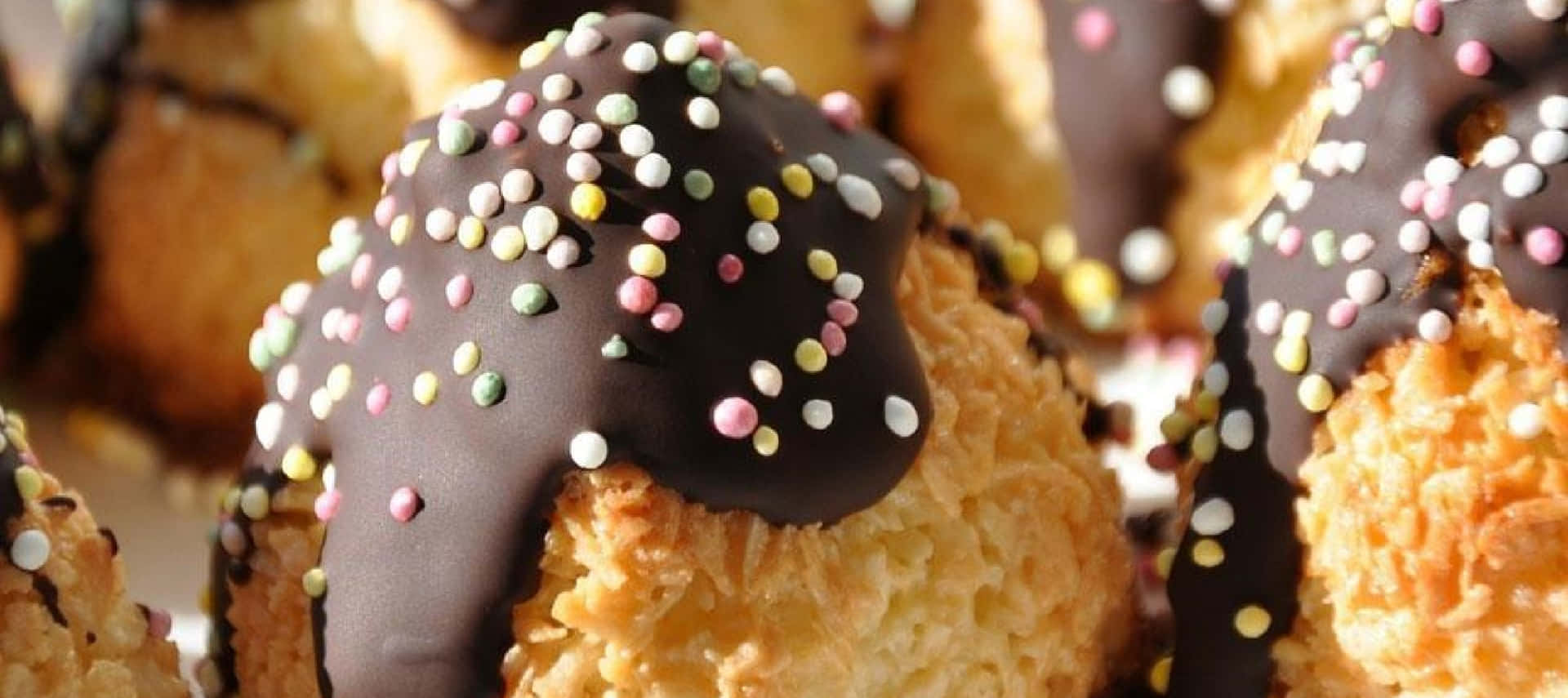 A Plate Of Chocolate Covered Pastries With Sprinkles