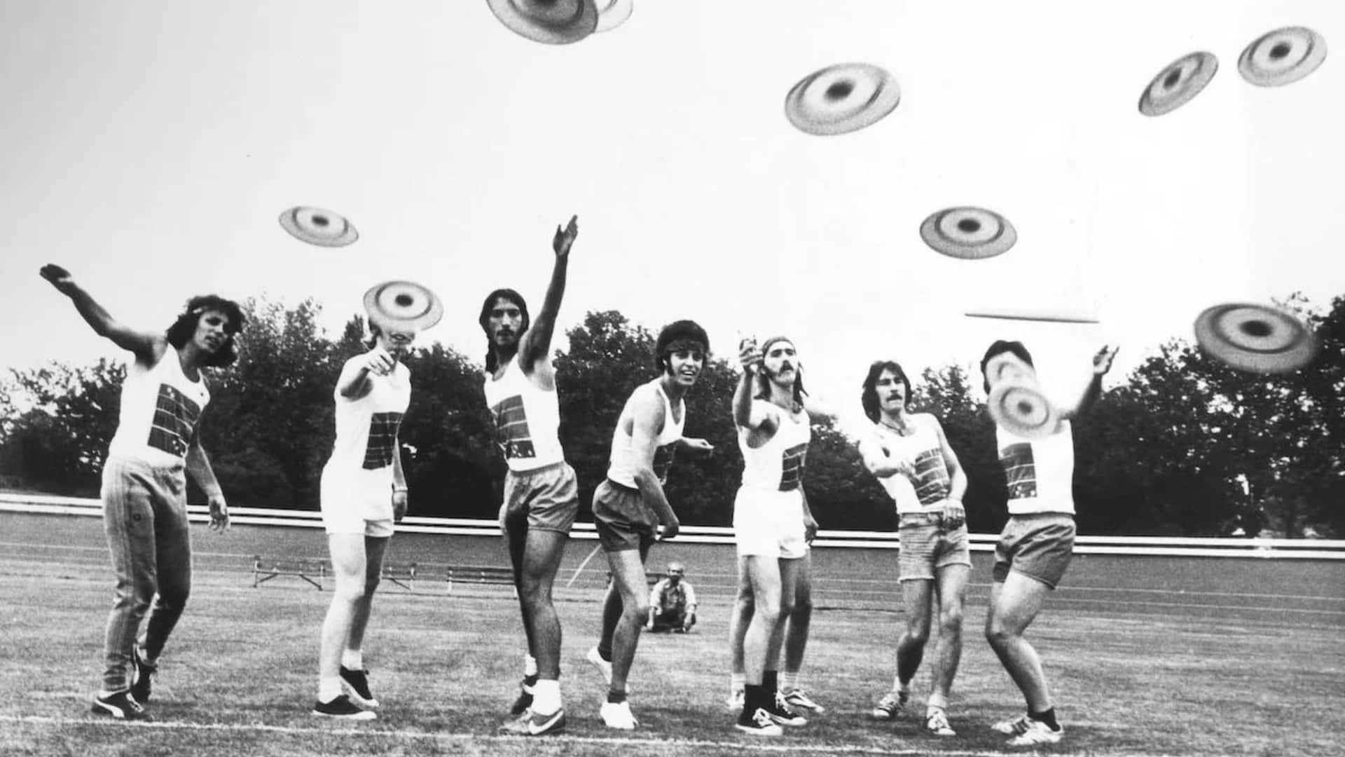 A Group Of People Throwing Frisbees
