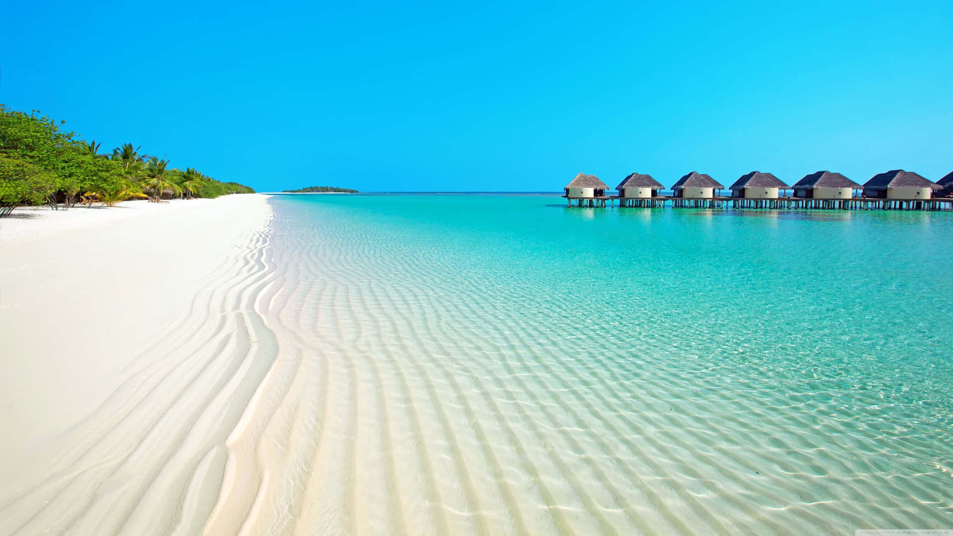 Unaspiaggia Di Sabbia Bianca Con Capanne E Un Oceano Blu Sfondo