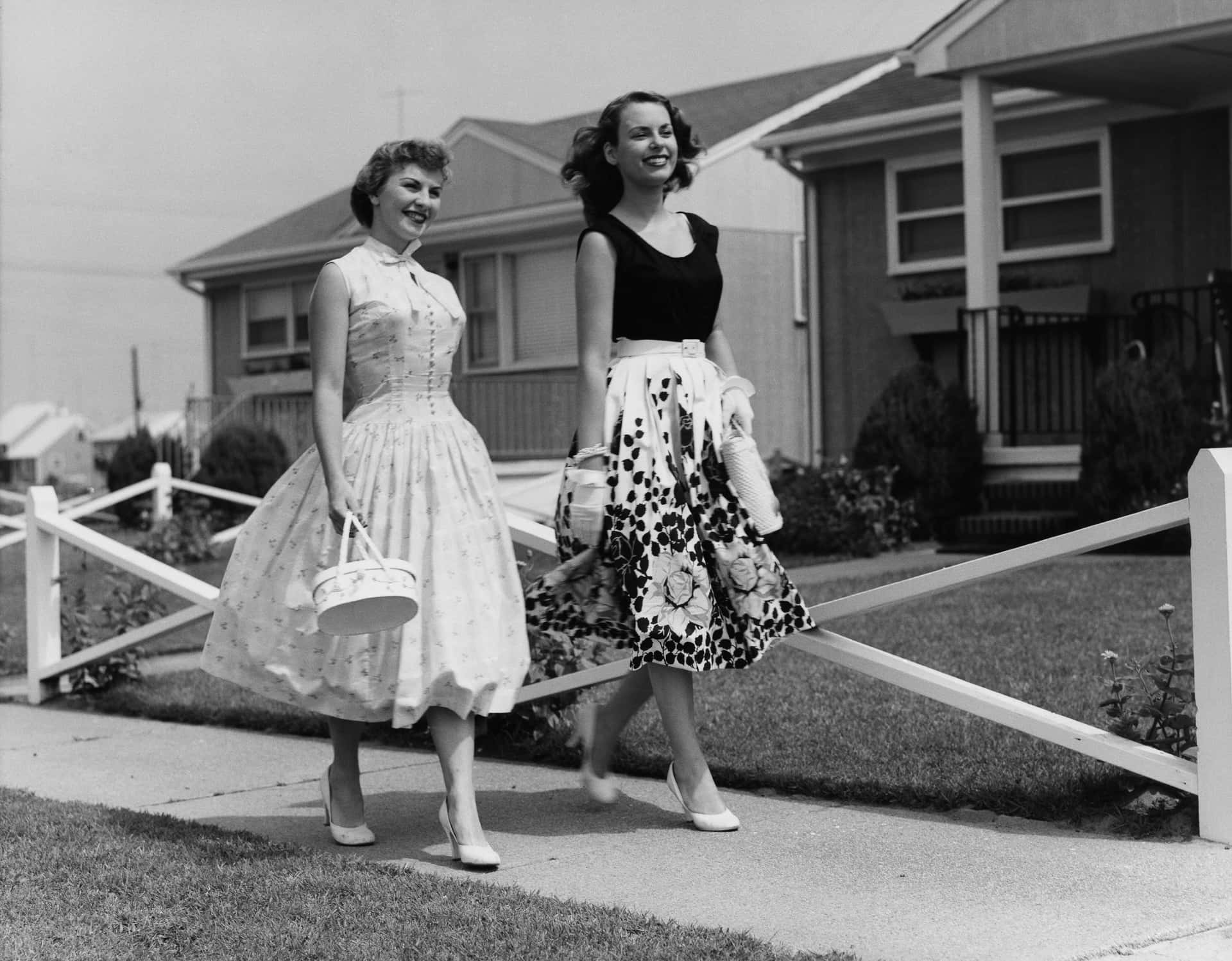 Zweifrauen In Kleidern Gehen Die Straße Entlang.
