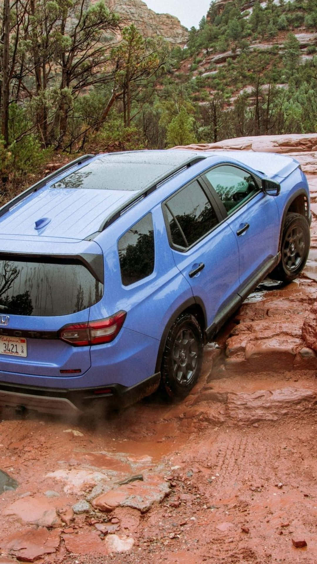 The Blue 2020 Subaru Outback Is Driving Through A Rocky Area