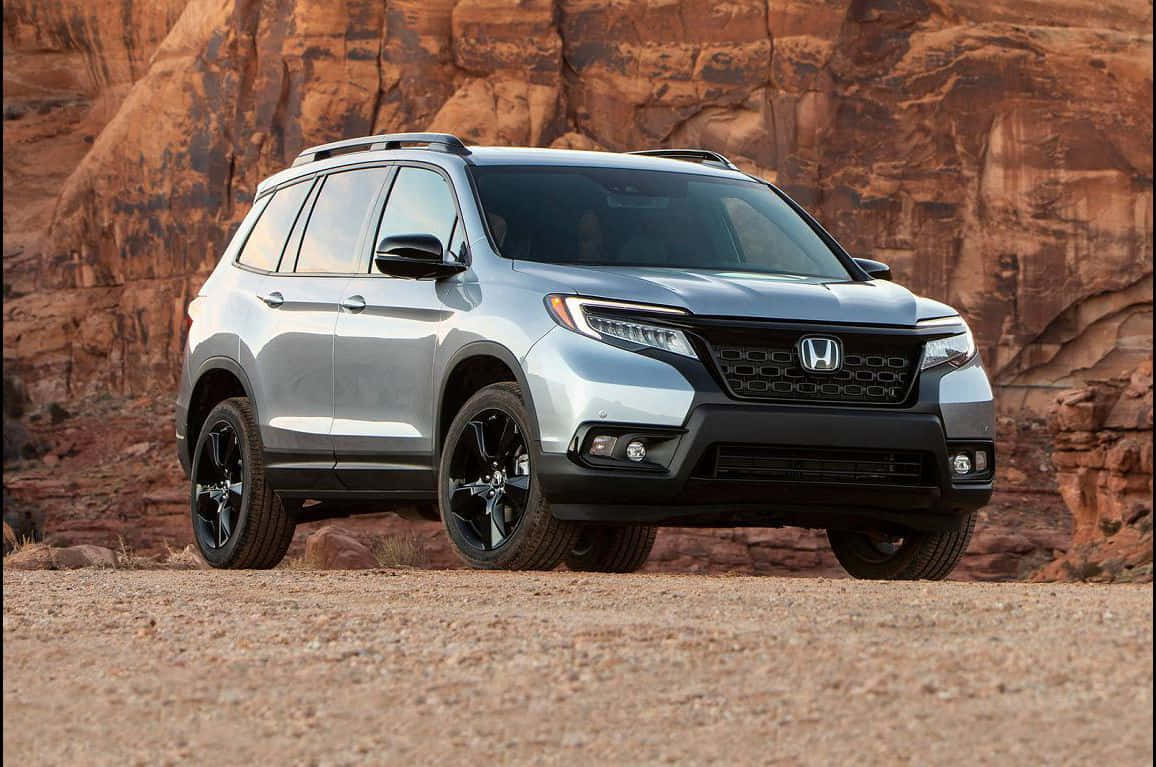 The 2019 Honda Passport Is Parked In Front Of A Rock