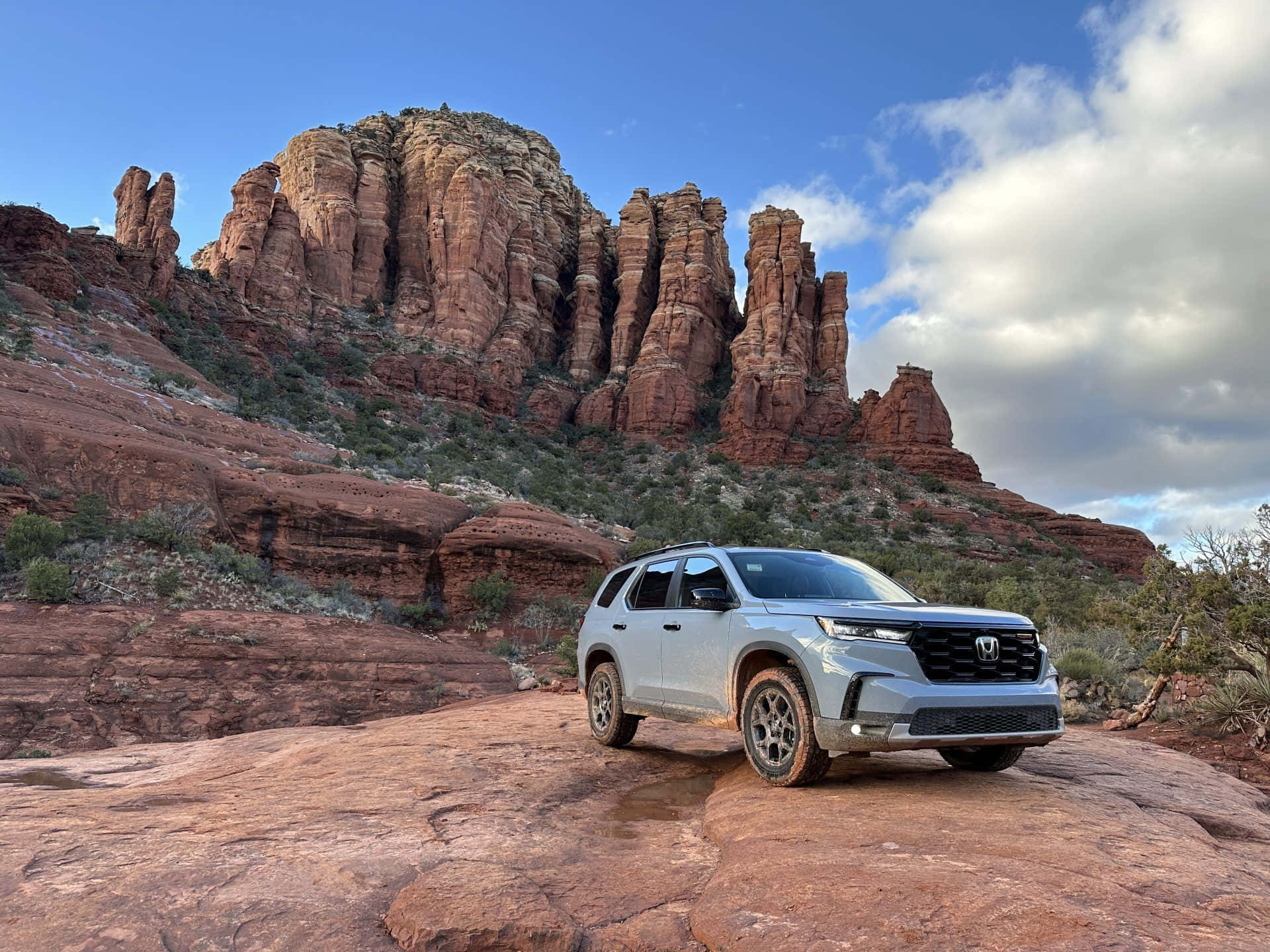 The 2019 Honda Pilot Is Parked On A Rock In Front Of A Red Rock